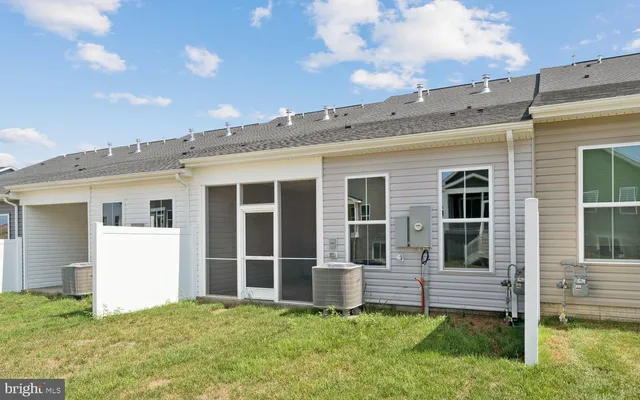 a view of a house with a yard and a large tree