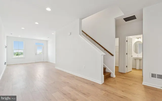 a view of a hallway with wooden floor and staircase