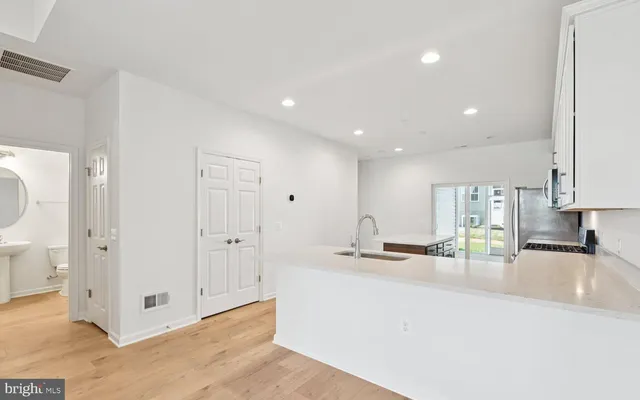 a kitchen with stainless steel appliances granite countertop a sink and white cabinets