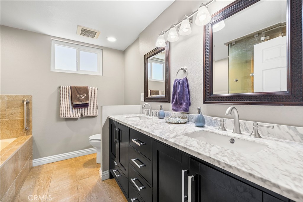 18770 Tribune Street Porter Ranch, CA 91326 - Photo 20 of 30 a bathroom with a granite countertop double vanity sink and a mirror