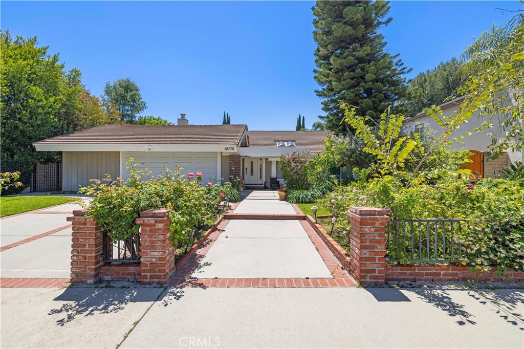 18770 Tribune Street Porter Ranch, CA 91326 - Photo 2 of 30 a front view of a house with a yard and potted plants