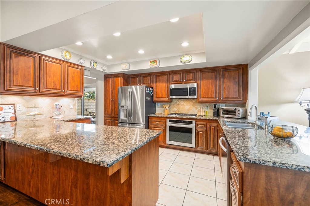 18770 Tribune Street Porter Ranch, CA 91326 - Photo 8 of 30 a kitchen with stainless steel appliances granite countertop a sink stove and refrigerator