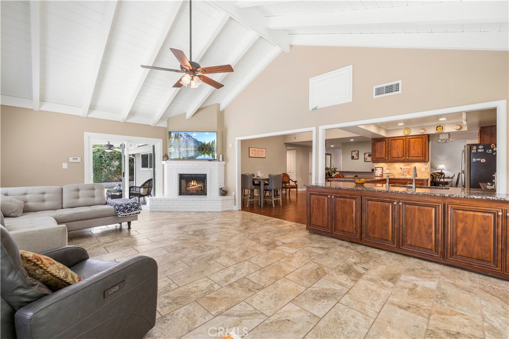 18770 Tribune Street Porter Ranch, CA 91326 - Photo 10 of 30 a large living room with stainless steel appliances furniture a large window and a fireplace