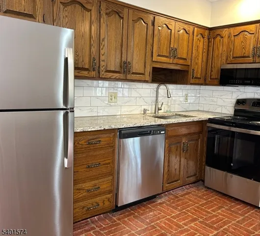 a kitchen with granite countertop a refrigerator and a sink