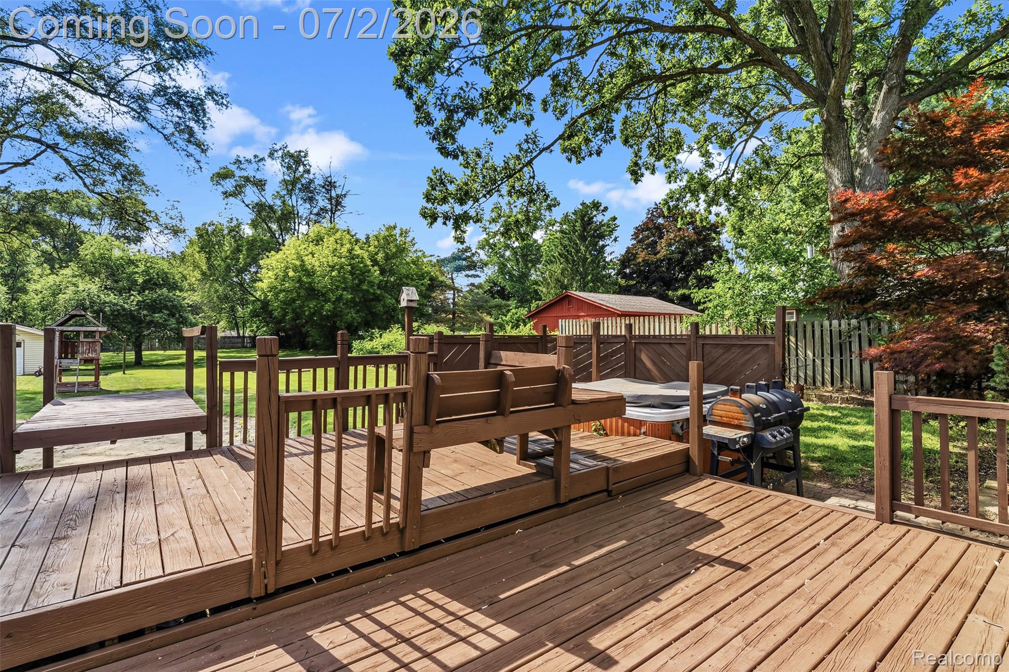 305 East Road Holly, MI 48442 - Photo 33 of 41 Expansive multi-level wood deck featuring built-in hot tub, privacy screening, and multiple distinct activity areas