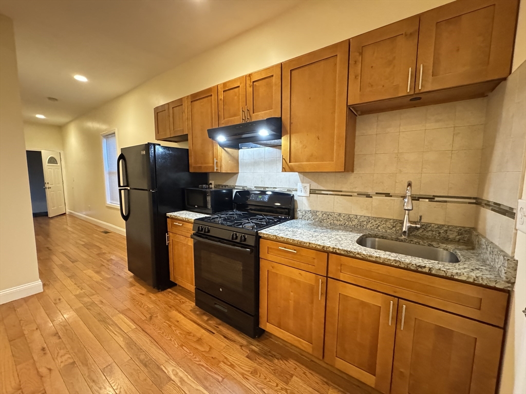 a kitchen with stainless steel appliances granite countertop a sink stove and refrigerator