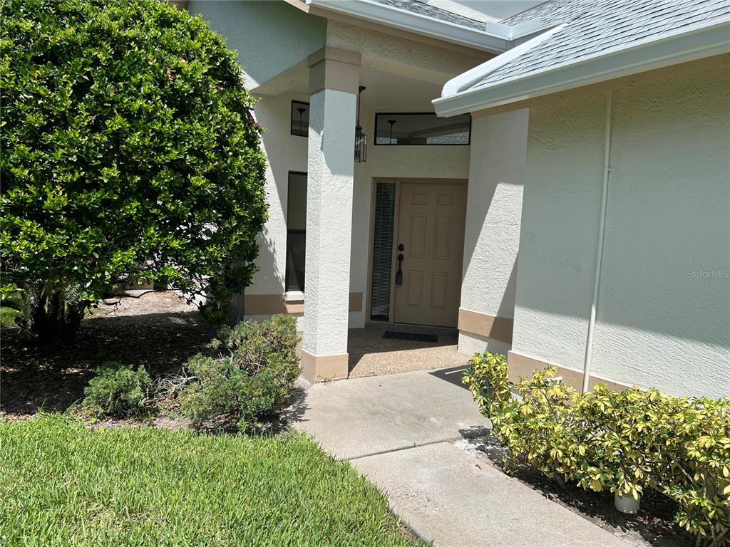 9108 Bassett Lane, Unit B New Port Richey, FL 34655 - Photo 3 of 66 a view of a house with a yard and plants