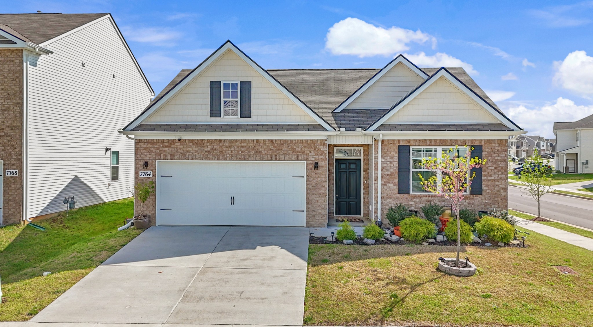 a front view of a house with a yard and potted plants