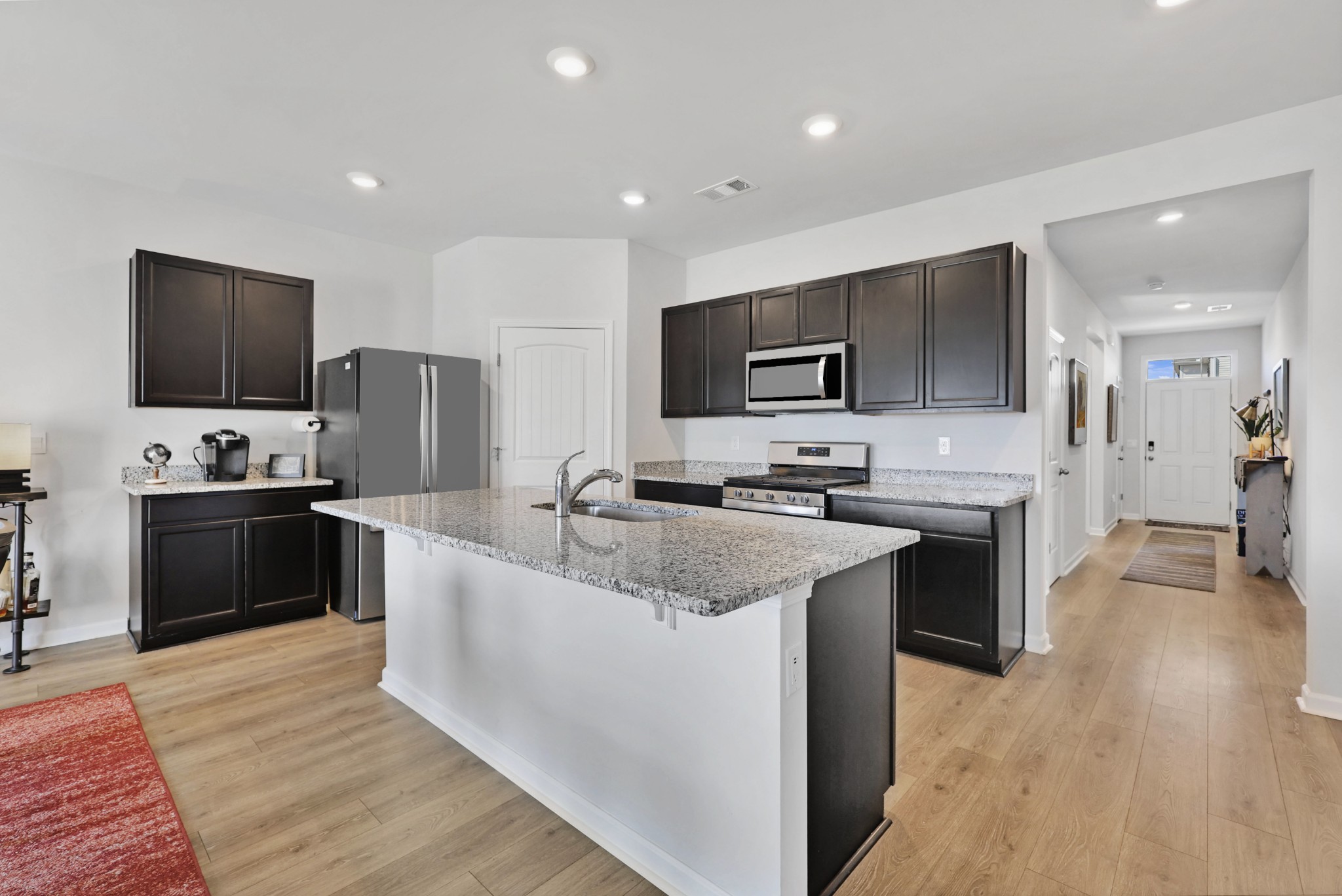 7764 Stapleton Chase Drive Antioch, TN 37013 - Photo 7 of 31 a large kitchen with stainless steel appliances kitchen island granite countertop a stove top oven a refrigerator a sink and dishwasher with wooden floor