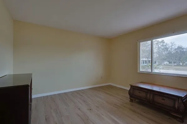 a view of a room with wooden floor lounge chair and windows