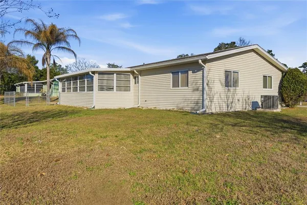 a kitchen with granite countertop a refrigerator and white cabinets