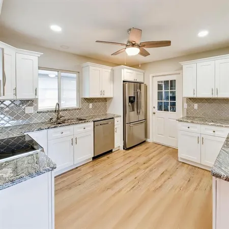 a kitchen with granite countertop cabinets and white appliances