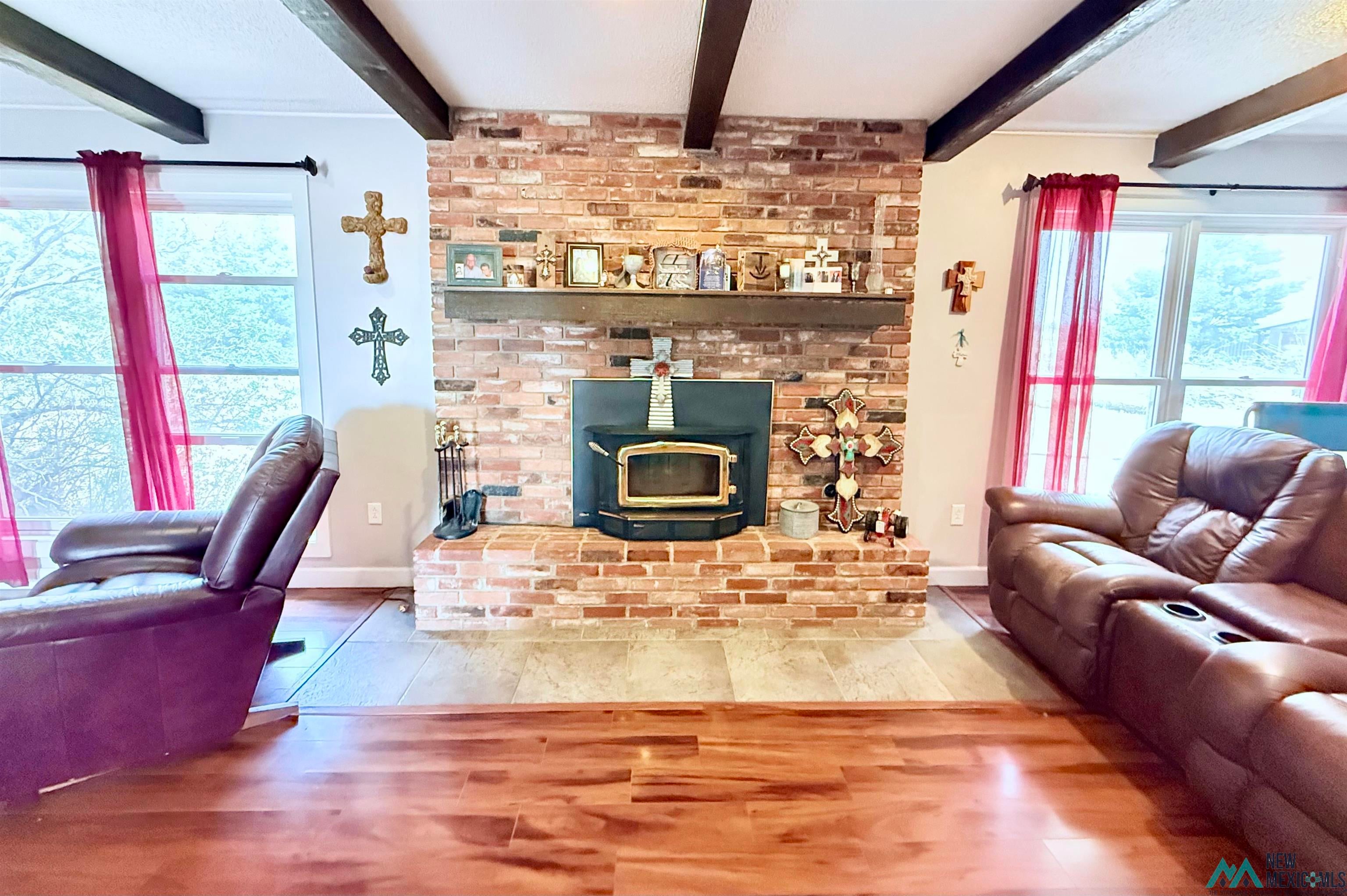 997 State Rte 108 Texico, NM 88135 - Photo 13 of 33 Living area with a prominent brick fireplace featuring an integrated wood-burning insert