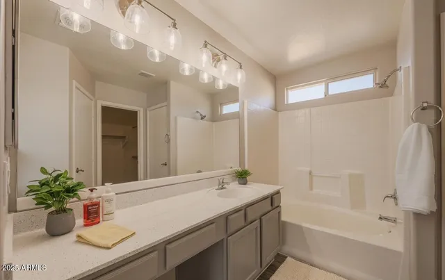 a bathroom with a granite countertop sink a mirror and a shower
