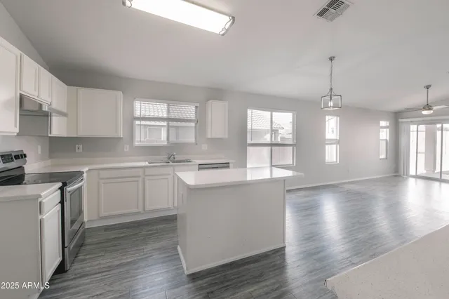 a kitchen with a white cabinets wooden floor and a sink
