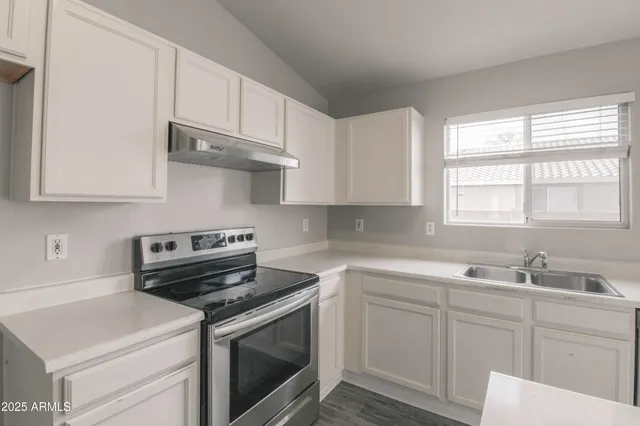a kitchen with stainless steel appliances white cabinets and a sink