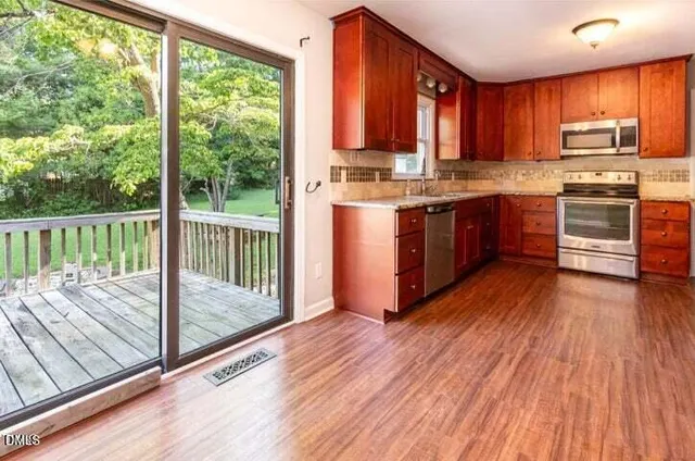 a kitchen with granite countertop wooden floors a stove and a sink