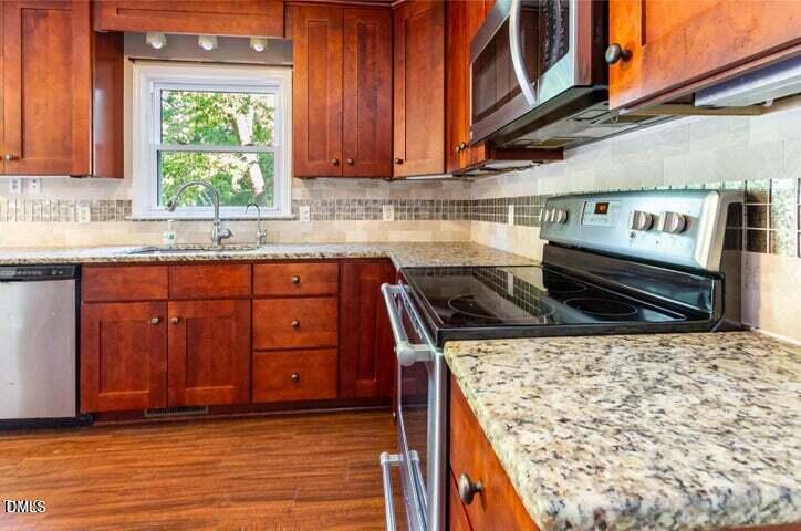 3209 Marie Drive Raleigh, NC 27604 - Photo 18 of 40 a kitchen with a stove a sink and a microwave