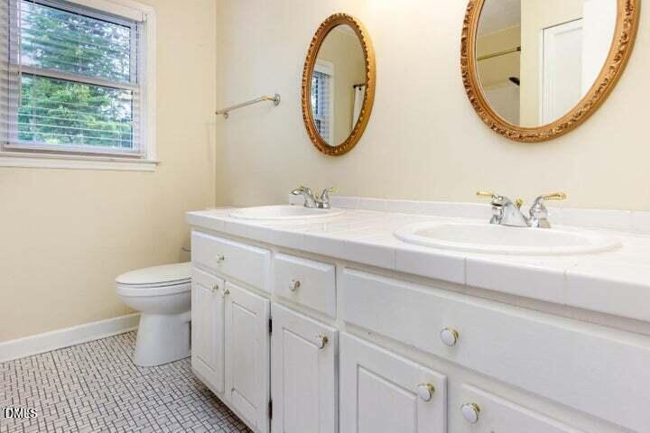 3209 Marie Drive Raleigh, NC 27604 - Photo 29 of 40 a bathroom with a toilet a sink and a mirror