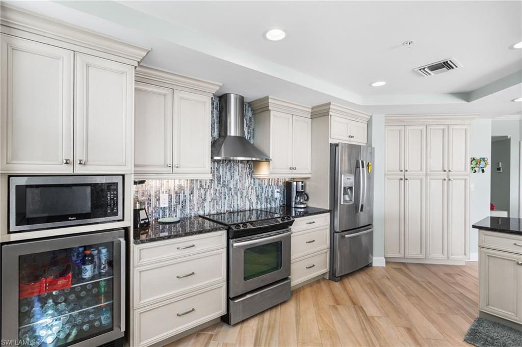 4975 Bonita Beach Road Southwest Bonita Springs, FL 34134 - Photo 15 of 49 Additional beverage fridge, built in microwave, stainless appliances and oven hood.