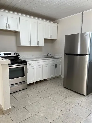 a kitchen with a stove a refrigerator and cabinets