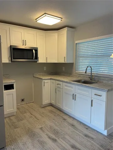 a kitchen with granite countertop white cabinets and stainless steel appliances