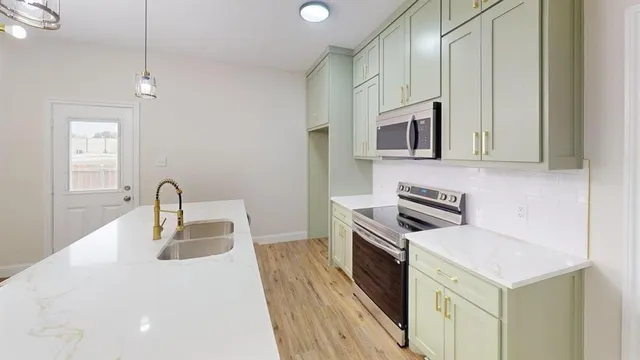 a kitchen with stainless steel appliances granite countertop a sink stove and microwave