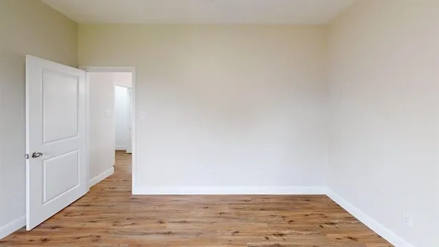 a view of an empty room with wooden floor