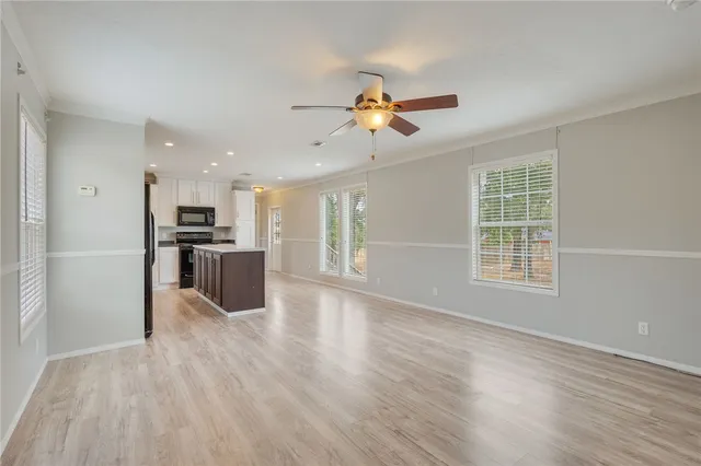 a view of kitchen with cabinets stainless steel appliances and wooden floor