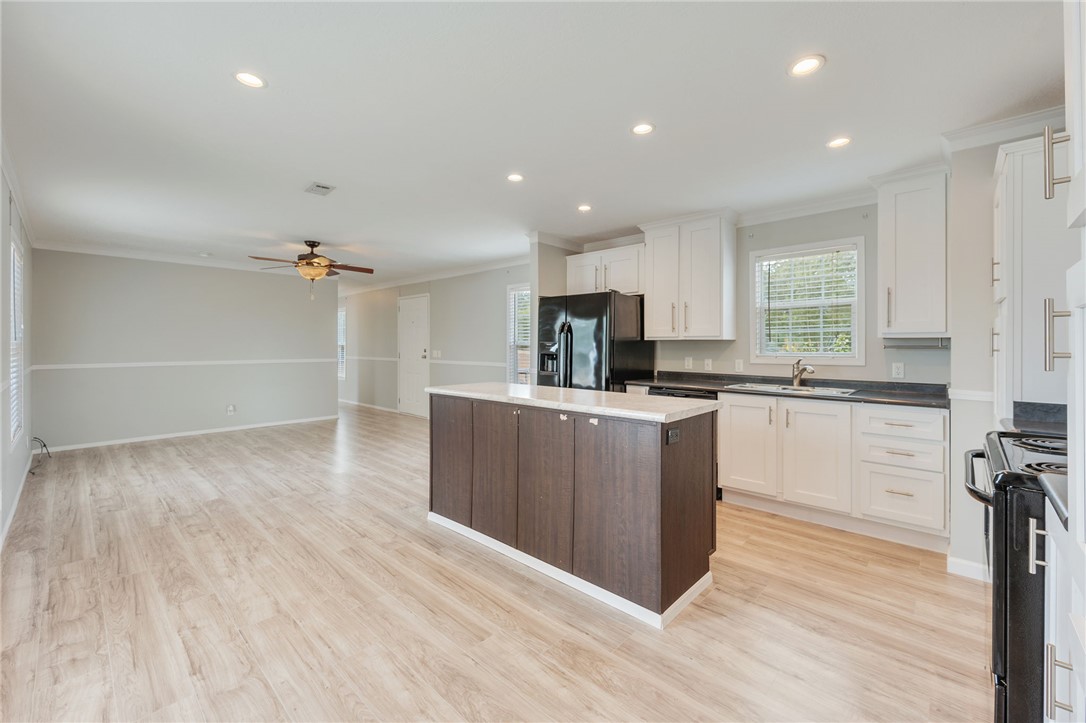 9144 Hensarling Lane Bryan, TX 77808 - Photo 9 of 25 a kitchen with stainless steel appliances granite countertop a refrigerator a sink dishwasher a stove and white countertops with wooden floor