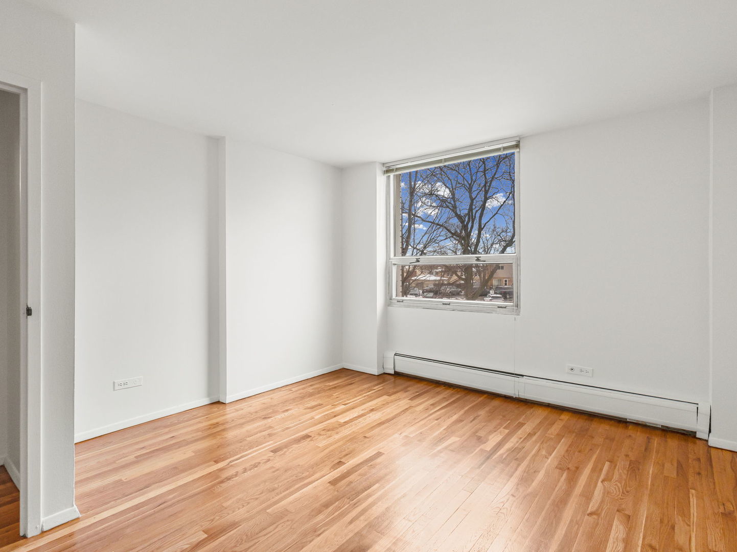 9009 Golf Road, Unit 2A Des Plaines, IL 60016 - Photo 13 of 18 a view of an empty room with window and wooden floor