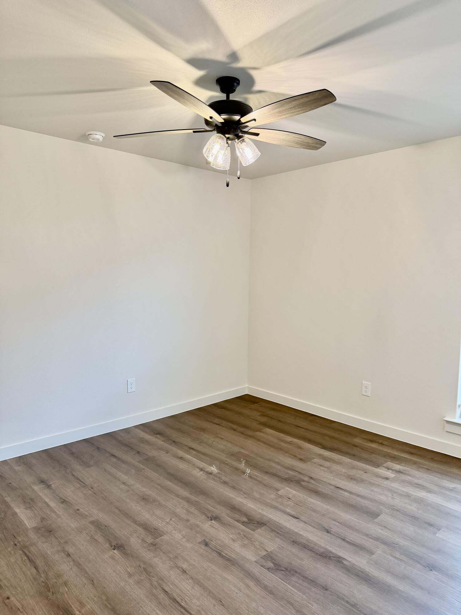 7007 16th Street Lubbock, TX 79416 - Photo 26 of 32 a view of a room with wooden floor a ceiling fan and window