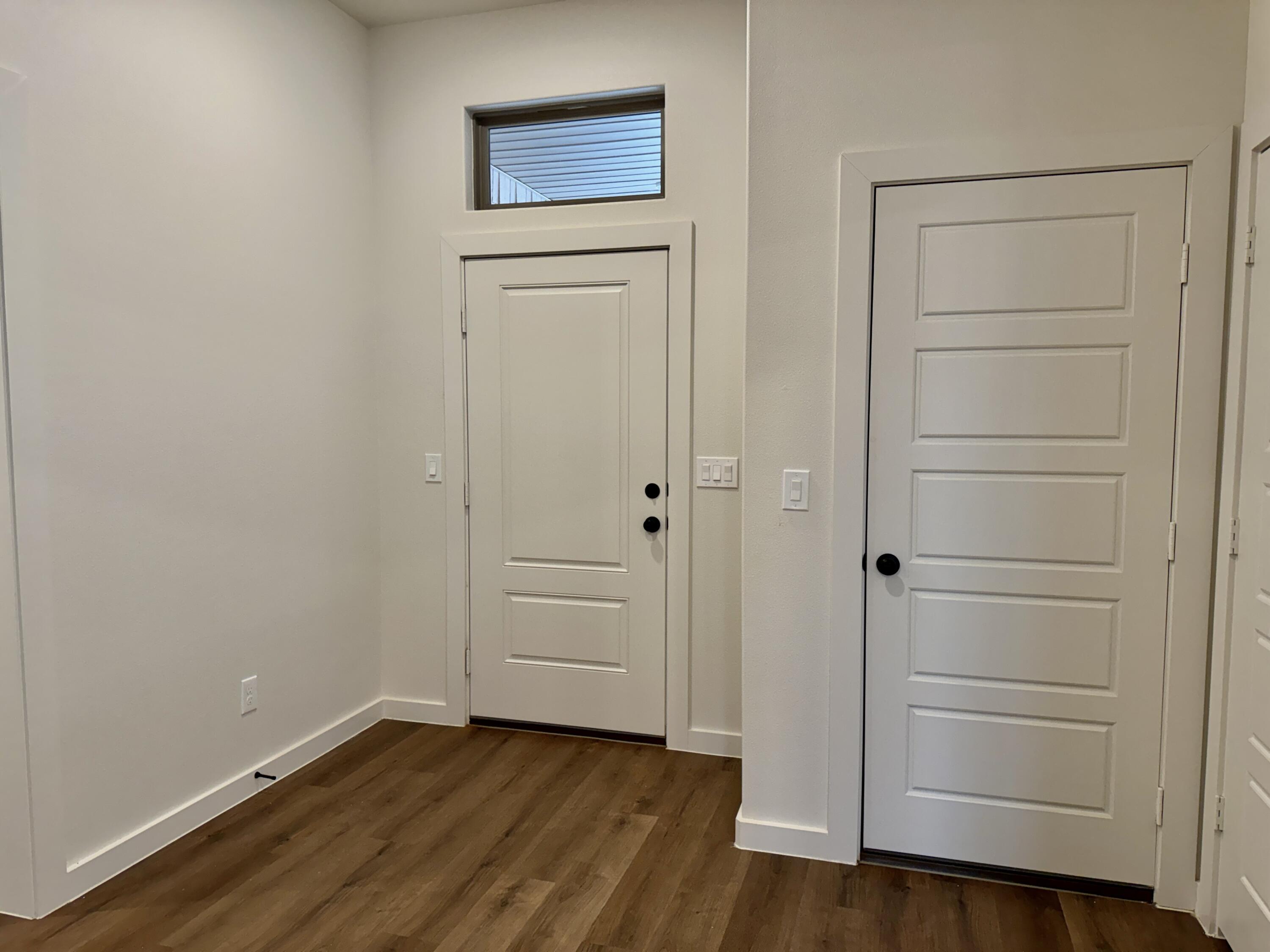 7007 16th Street Lubbock, TX 79416 - Photo 4 of 32 an empty room with wooden floor & cabinet
