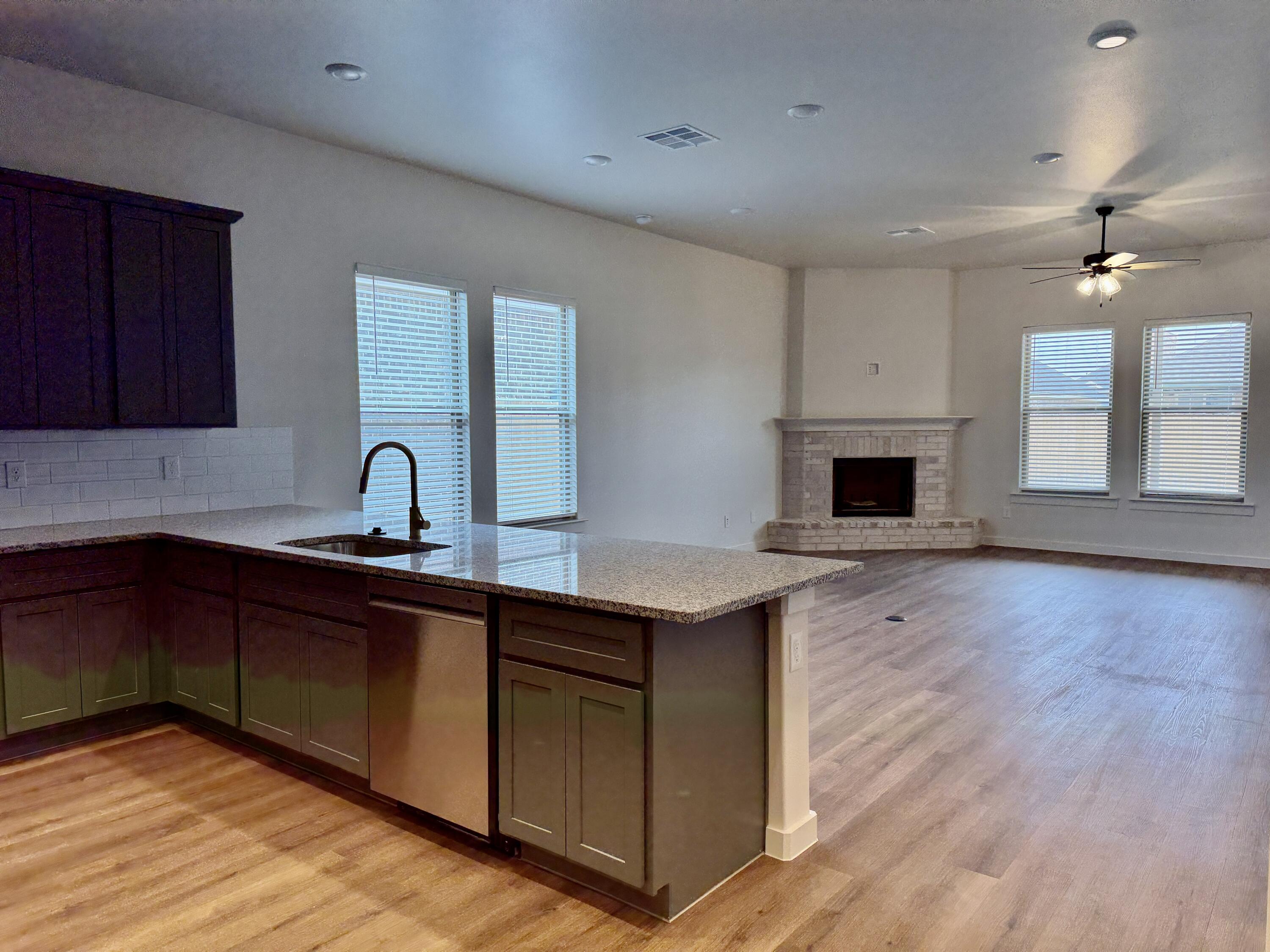 7007 16th Street Lubbock, TX 79416 - Photo 7 of 32 a kitchen with sink cabinets and wooden floor