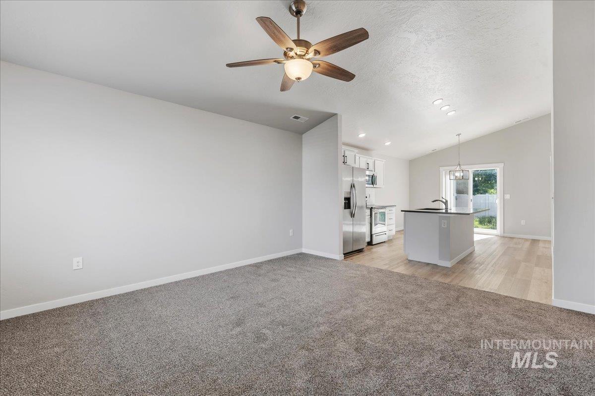 3091 S Green Boise, ID 83709 - Photo 7 of 27 Open-concept interior featuring a vaulted ceiling and a ceiling fan with integrated lighting