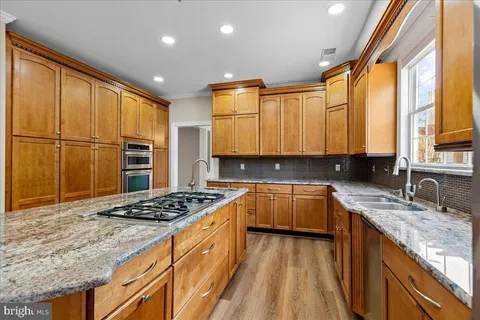 a kitchen with stainless steel appliances granite countertop a stove a sink and a refrigerator