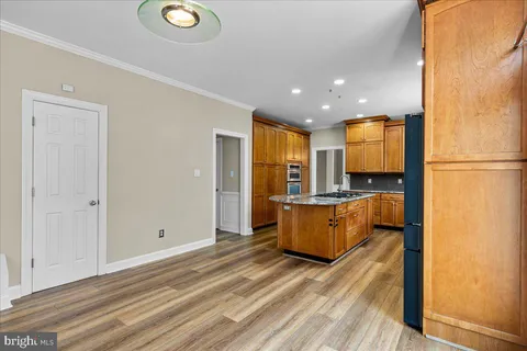a view of kitchen with stainless steel appliances granite countertop a refrigerator and a stove top oven