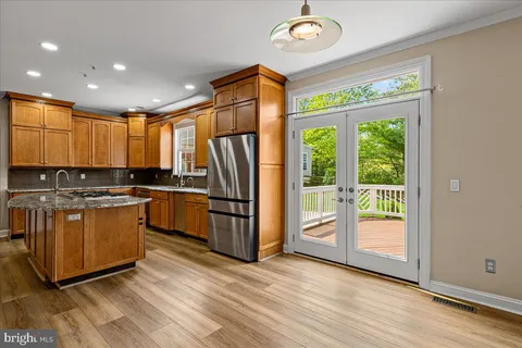 a kitchen with stainless steel appliances granite countertop a refrigerator a stove a sink and a large window