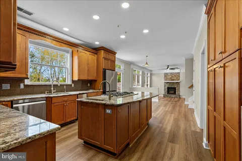 a kitchen with stainless steel appliances granite countertop sink stove top oven and cabinets
