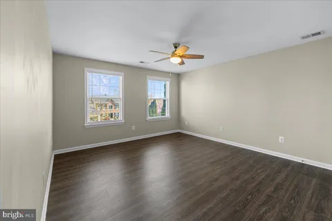 an empty room with windows and wooden floor