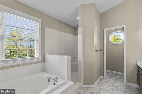 a bathroom with a bathtub and a window