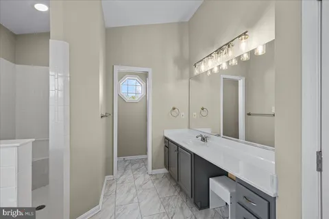a spacious bathroom with a double vanity sink a large mirror and shower