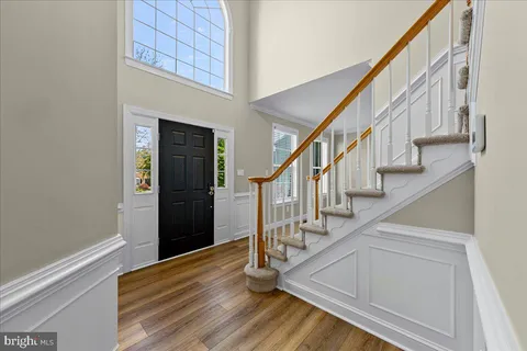 a view of staircase with lots of frames on wall and wooden floor