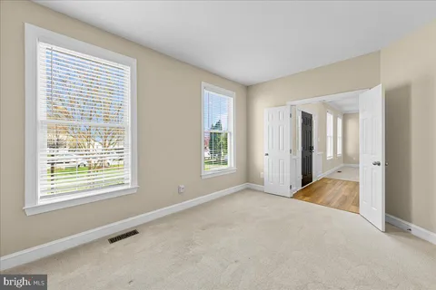 a view of an empty room with a window and a bathroom