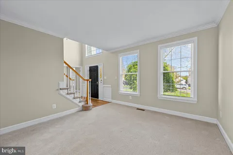 a view of an empty room with stairs and a window