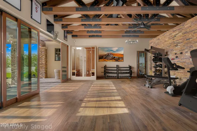 a view of a hall with wooden floor and windows