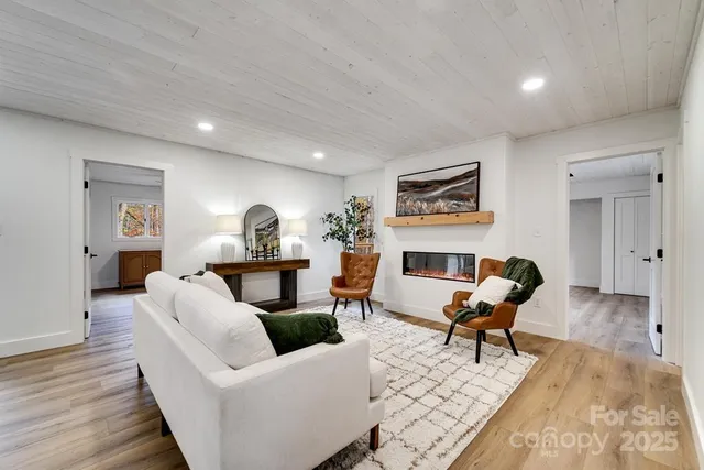 a living room with furniture fireplace and wooden floor
