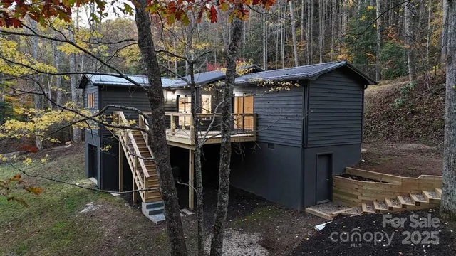 a view of a house with a tree and wooden fence