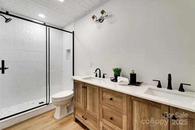 a bathroom with a double vanity sink toilet and shower