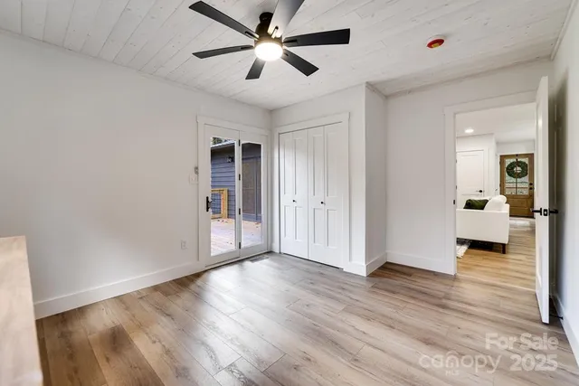 a view of a big room with wooden floor and a ceiling fan